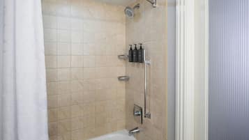 A bathroom with beige tiles, a shower, a bathtub, and a toilet.
