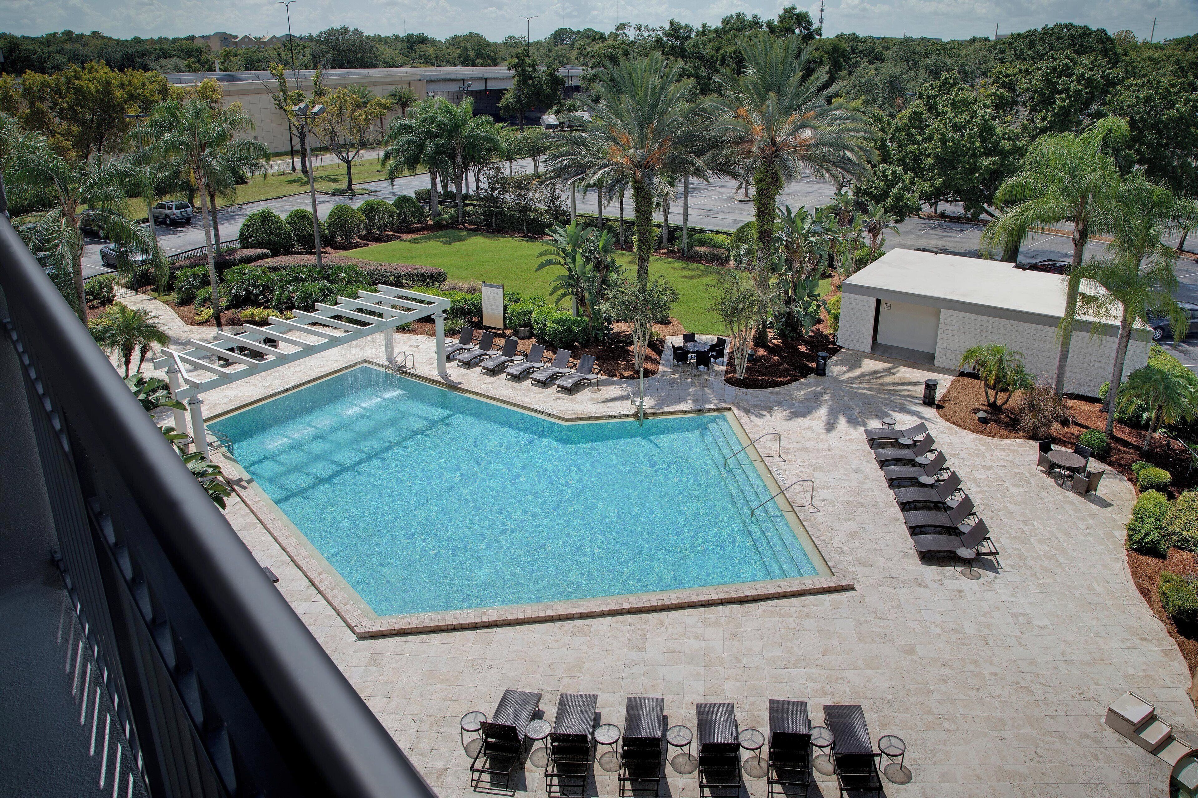Una piscina al aire libre, sillones reclinables de piscina