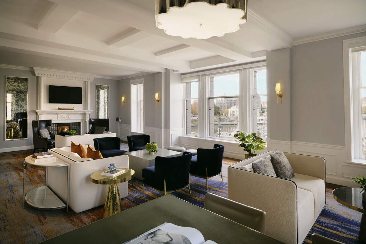 A spacious living area with a fireplace, modern furniture, and large windows offering city views.