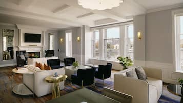 A spacious living area with a fireplace, modern furniture, and large windows offering city views.