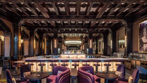 A bar area with a central bar, multiple seating arrangements, and ornate ceiling details. - Fairmont Empress (Victoria)