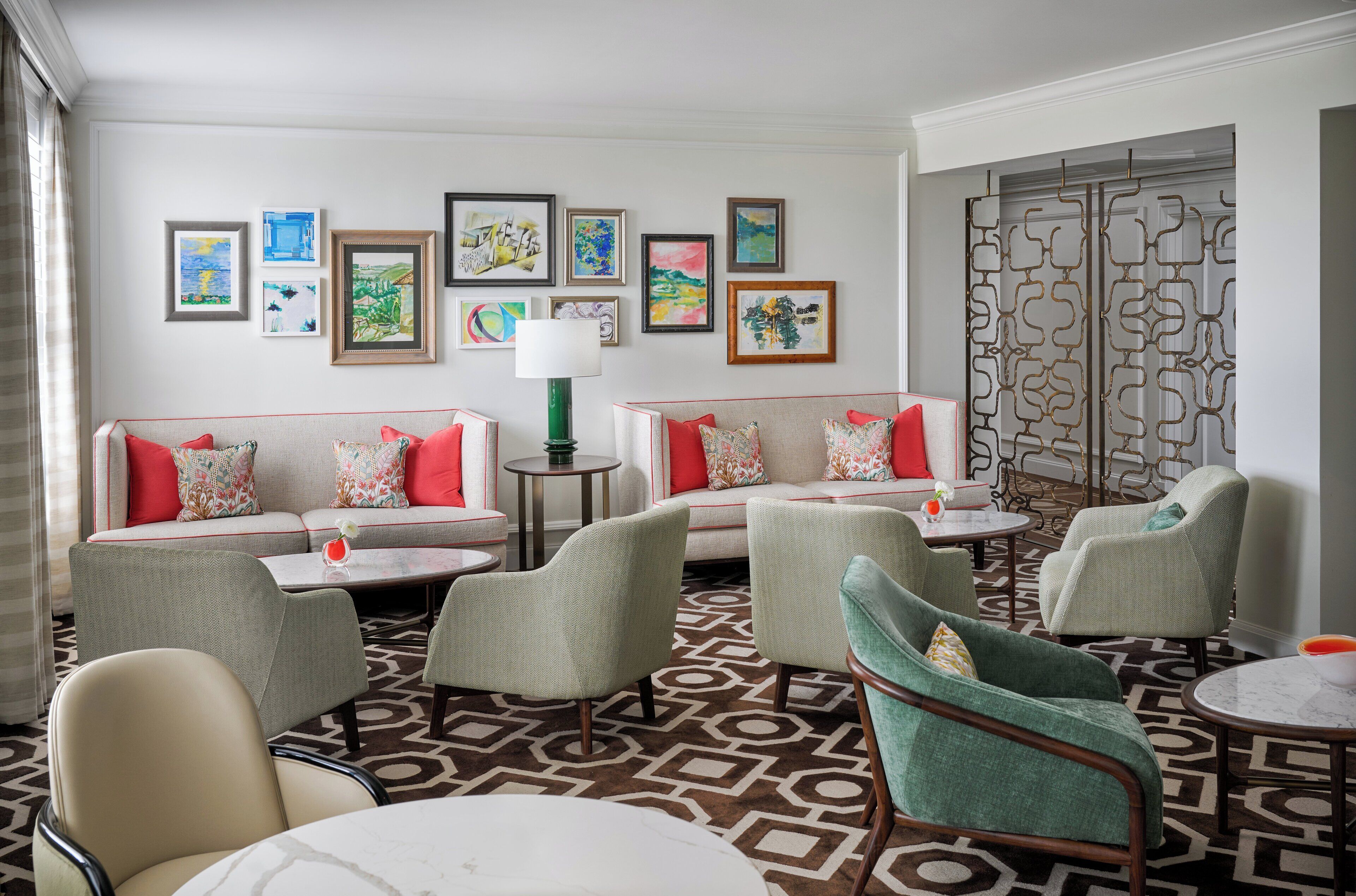 A modern lounge area with a sofa set, armchairs, and a patterned carpet.