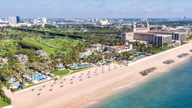 Un complejo turístico frente a la playa, con campo de golf y varias edificaciones hoteleras.