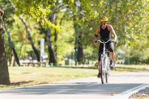 A person riding a bicycle on a paved path in a park. - Lindner Dusseldorf Seestern, Part of JdV by Hyatt (Düsseldorf)