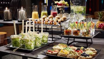 A buffet table with various food items and drinks.