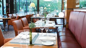 Un restaurante con mesas dispuestas para comer, con vistas a zonas verdes.