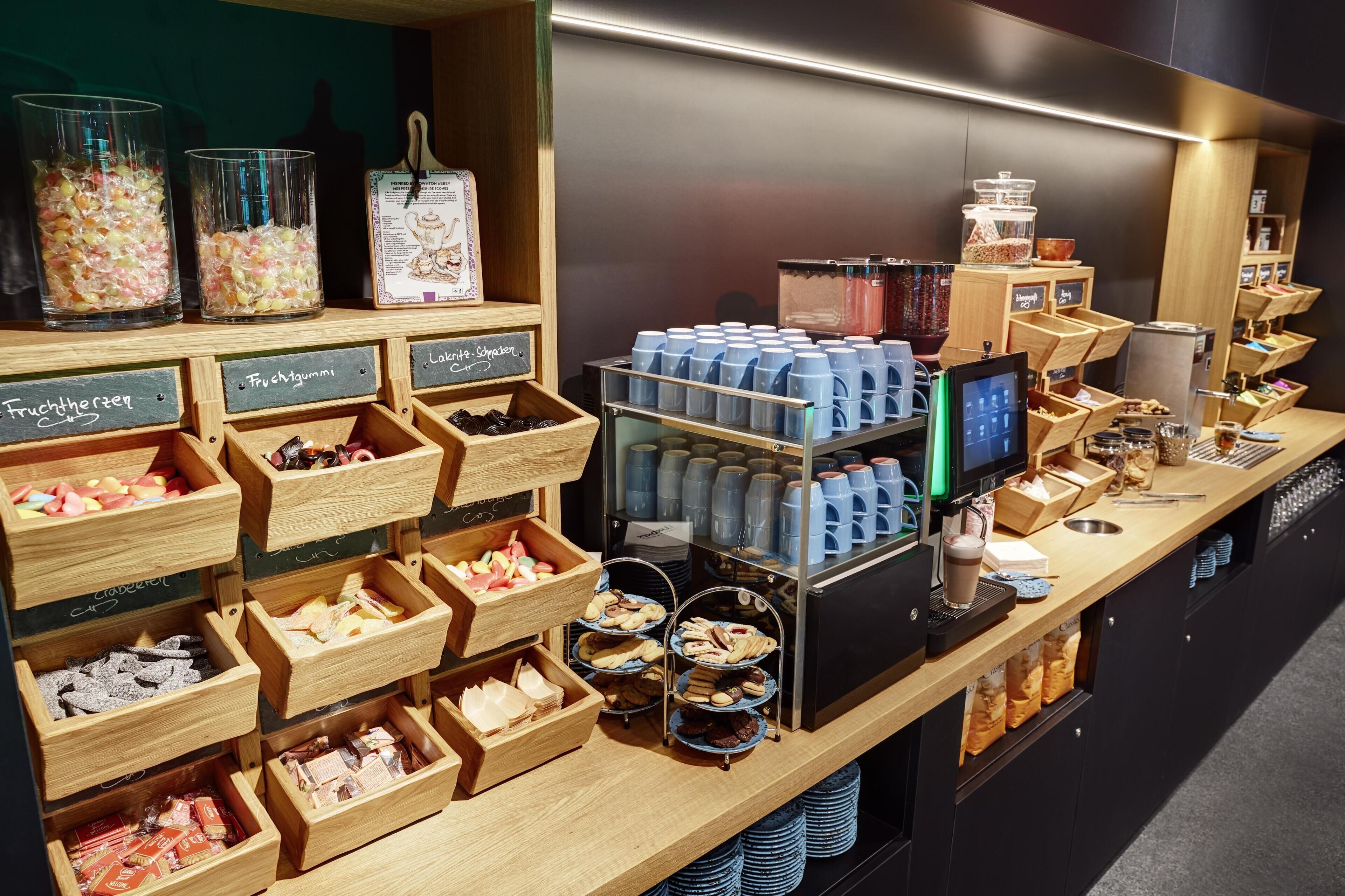 A café counter with various food items and a coffee machine.