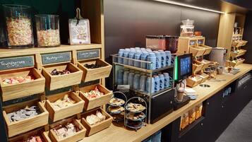 Un comptoir de café où sont exposés divers produits alimentaires, ainsi qu’une machine à café.