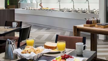 Un bufé de desayuno con diversas opciones de alimentos y una estación de café.