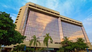 Doubletree-hotelli, jossa on suuri lasijulkisivu, ulkouima-allas ja aurinkotuoleja.