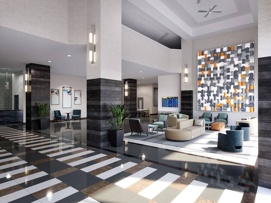 Un hall d’entrée moderne avec un sol à carreaux, un espace salon et un mur orné d’un motif géométrique.