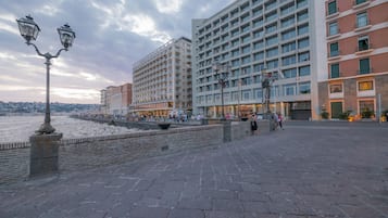 Eine Uferpromenade mit modernen Gebäuden, einer Steinmauer und einer Straßenlaterne.