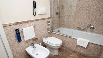 A bathroom with a toilet, bidet, and bathtub.