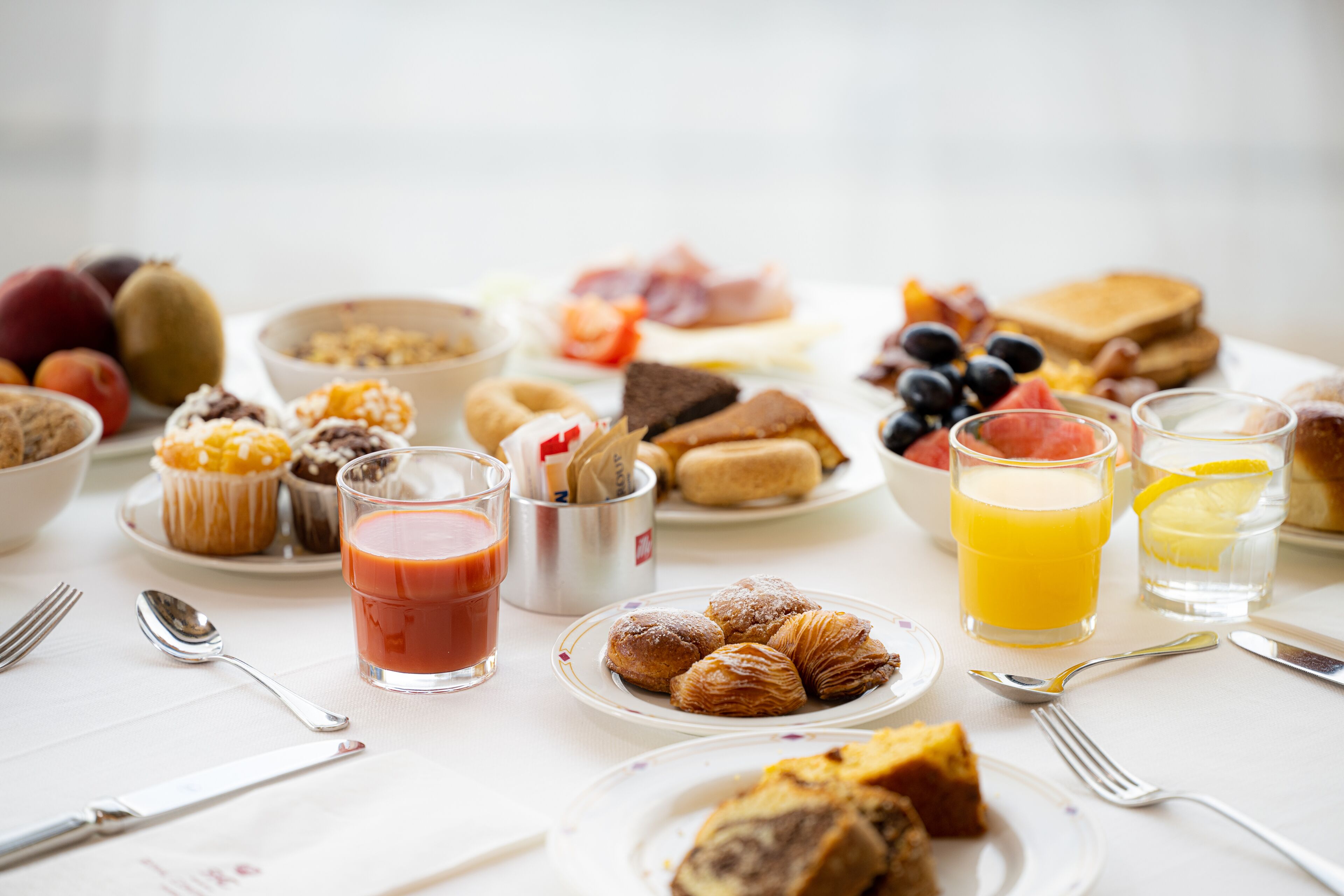 Een ontbijttafel met diverse soorten eten en drinken.