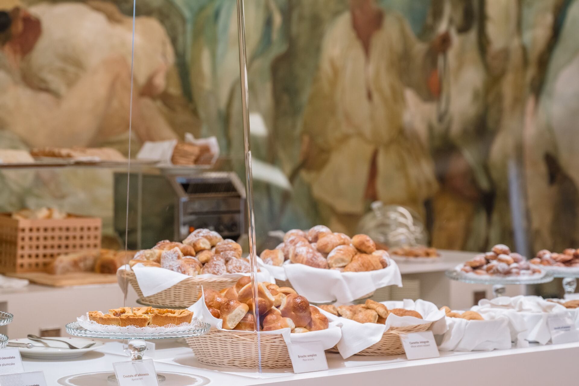 Un buffet proposant une variété de produits de boulangerie et de pâtisserie, présentés dans des paniers et sur des plats de service.