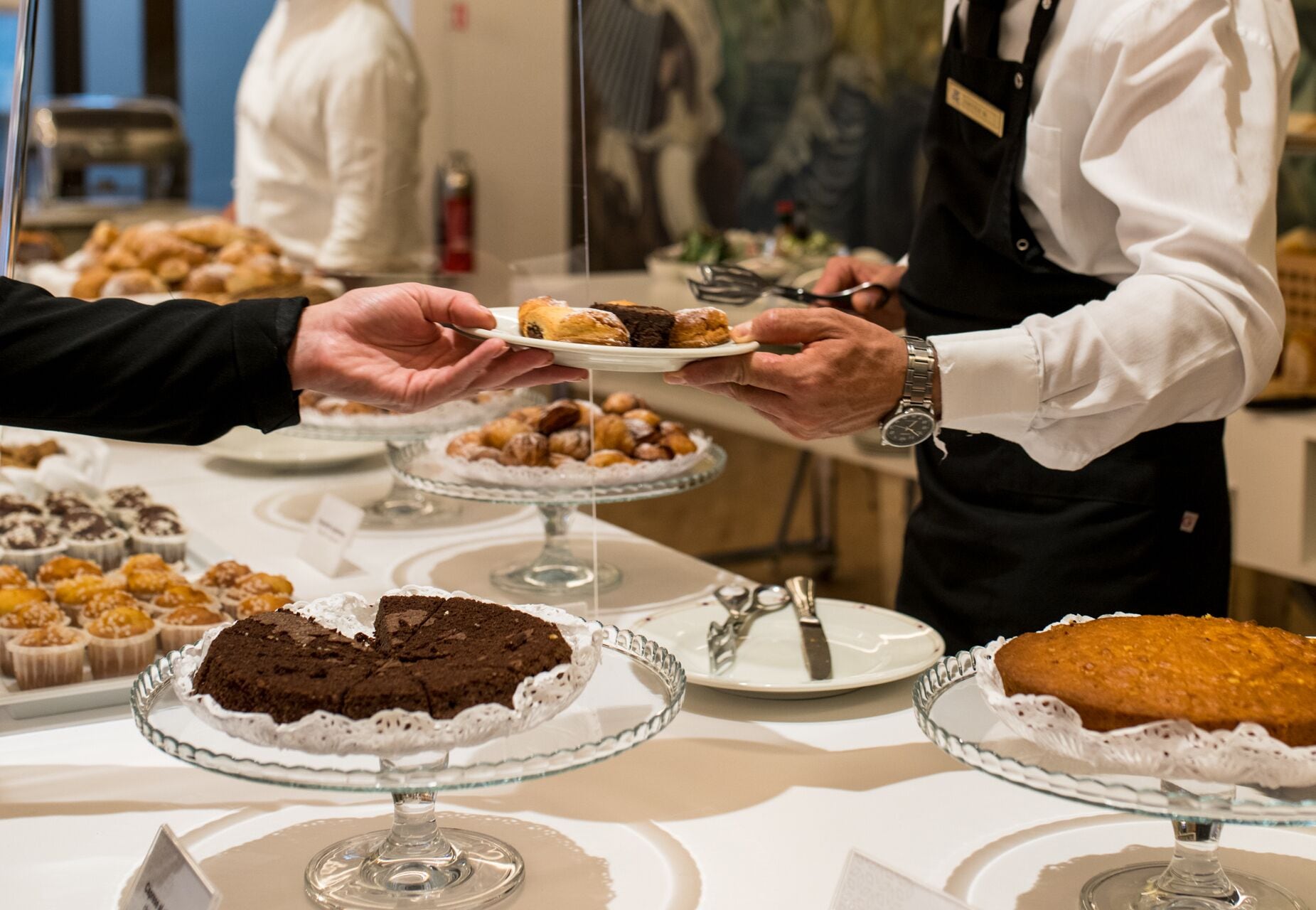 A buffet with various desserts on display, including cakes and pastries.