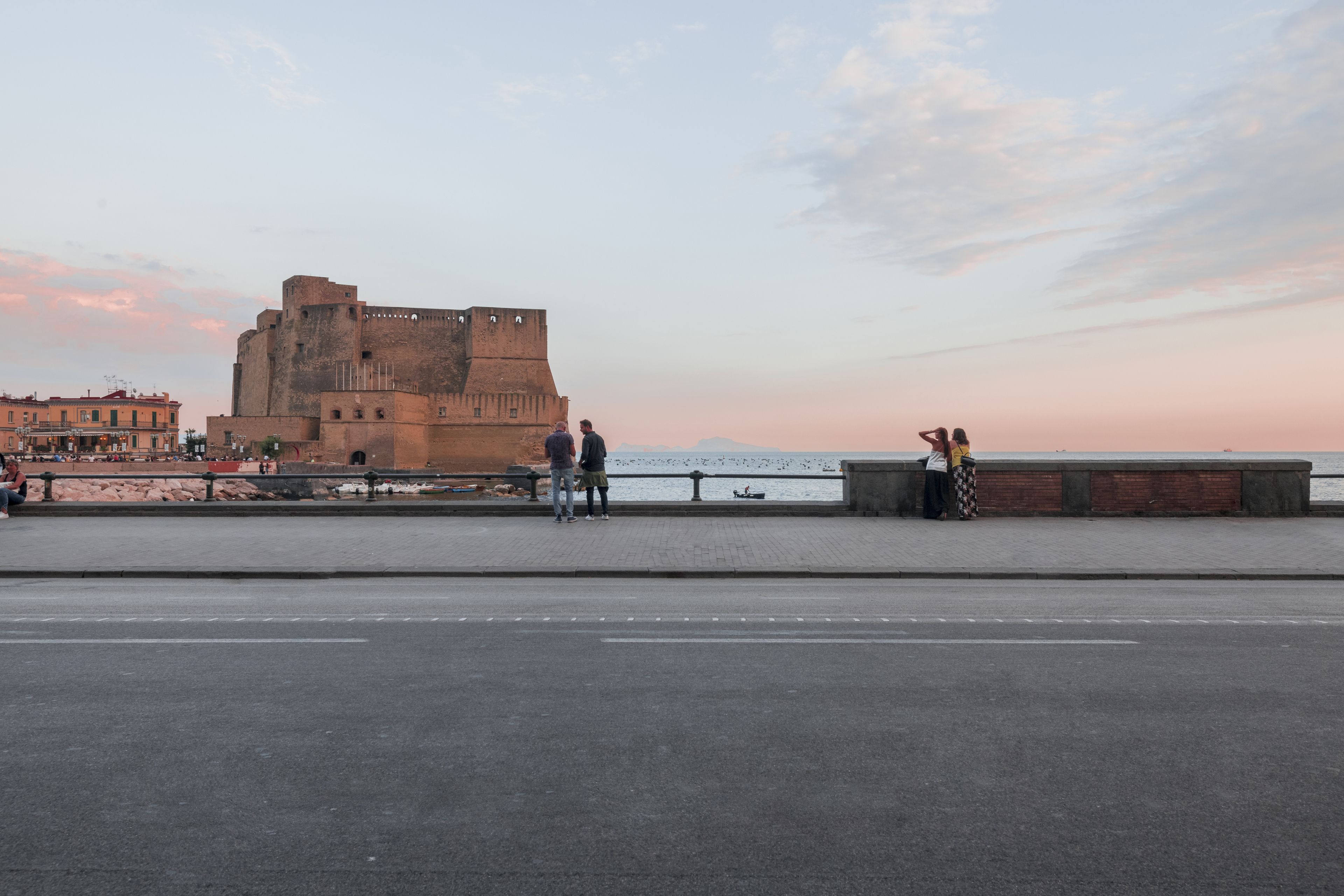 A historic fort with a paved walkway and a view of the sea.
