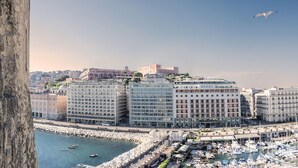 A marina with boats, a waterfront promenade, and buildings with balconies overlooking the water. - Royal Continental Hotel Naples (Naples)