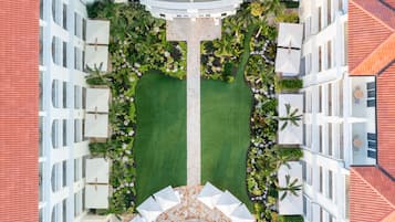 Vista aerea di un hotel con un cortile centrale, circondato da più piani con balconi e aree salotto all'aperto.