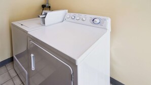 Una lavadora de carga frontal con panel de control, un picaporte y una perilla.
