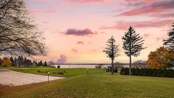 Een park met een picknickplaats, een gazon en uitzicht op het water.