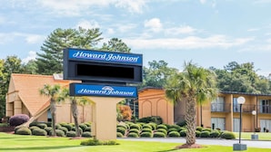 A Howard Johnson hotel sign with a modern building in the background. - Howard Johnson by Wyndham Athens (Athens)
