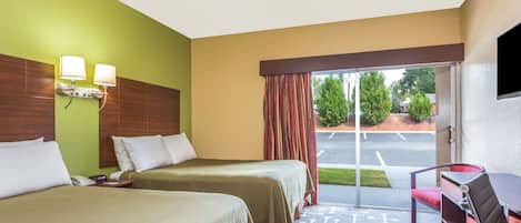 Una habitación de hotel con dos camas, un escritorio y una silla.