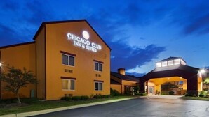 Un hotel con un cartel que dice 'Chicago Club Inn & Suites' de noche.