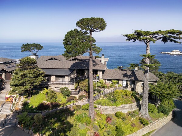 A coastal house with a stone facade, multiple decks, and a view of the sea. - Hyatt Carmel Highlands (Carmel)