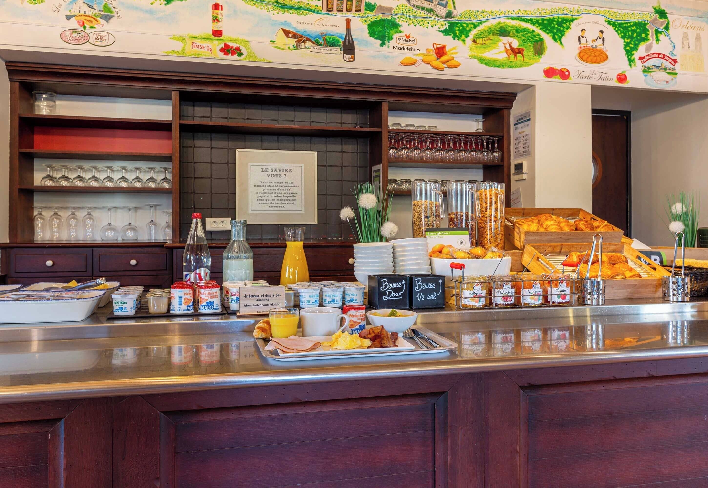 Un buffet de petit-déjeuner proposant une variété d’aliments, d’assaisonnements et de boissons.