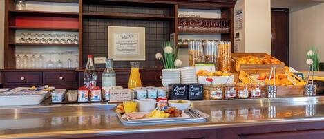 Un buffet de petit-déjeuner proposant une variété d’aliments, d’assaisonnements et de boissons.