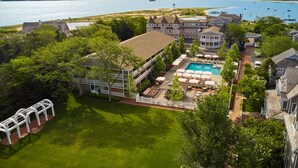 A resort with a swimming pool, outdoor seating, and a view of the lake. - Harbor View Hotel (Edgartown)