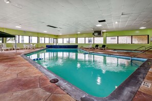 Relax by the pool surrounded by a hexagonal tile floor and lounge chairs.