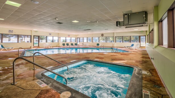 An indoor swimming pool with multiple lanes, lounge chairs, and a no diving sign.