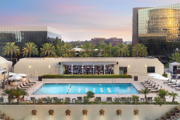 A rooftop pool with lounge chairs and palm trees, surrounded by modern buildings. - The Westin South Coast Plaza, Costa Mesa (Costa Mesa)