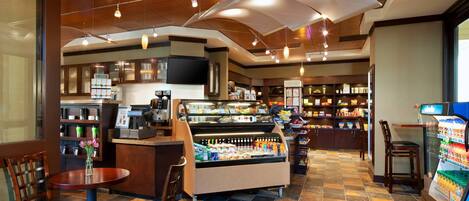 A restaurant with a counter, seating area, and a display case.