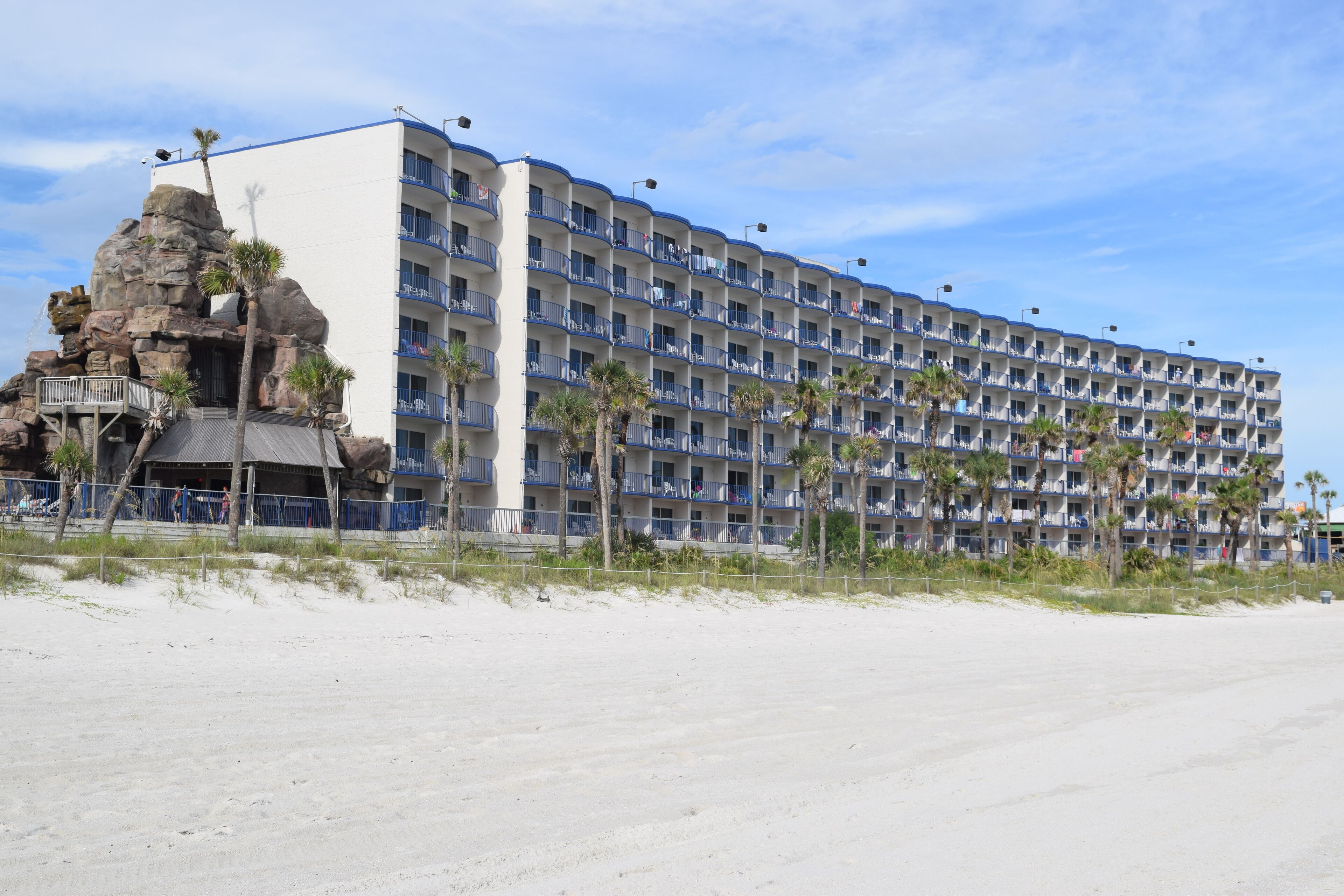 Um hotel grande com várias varandas e vista para a praia.