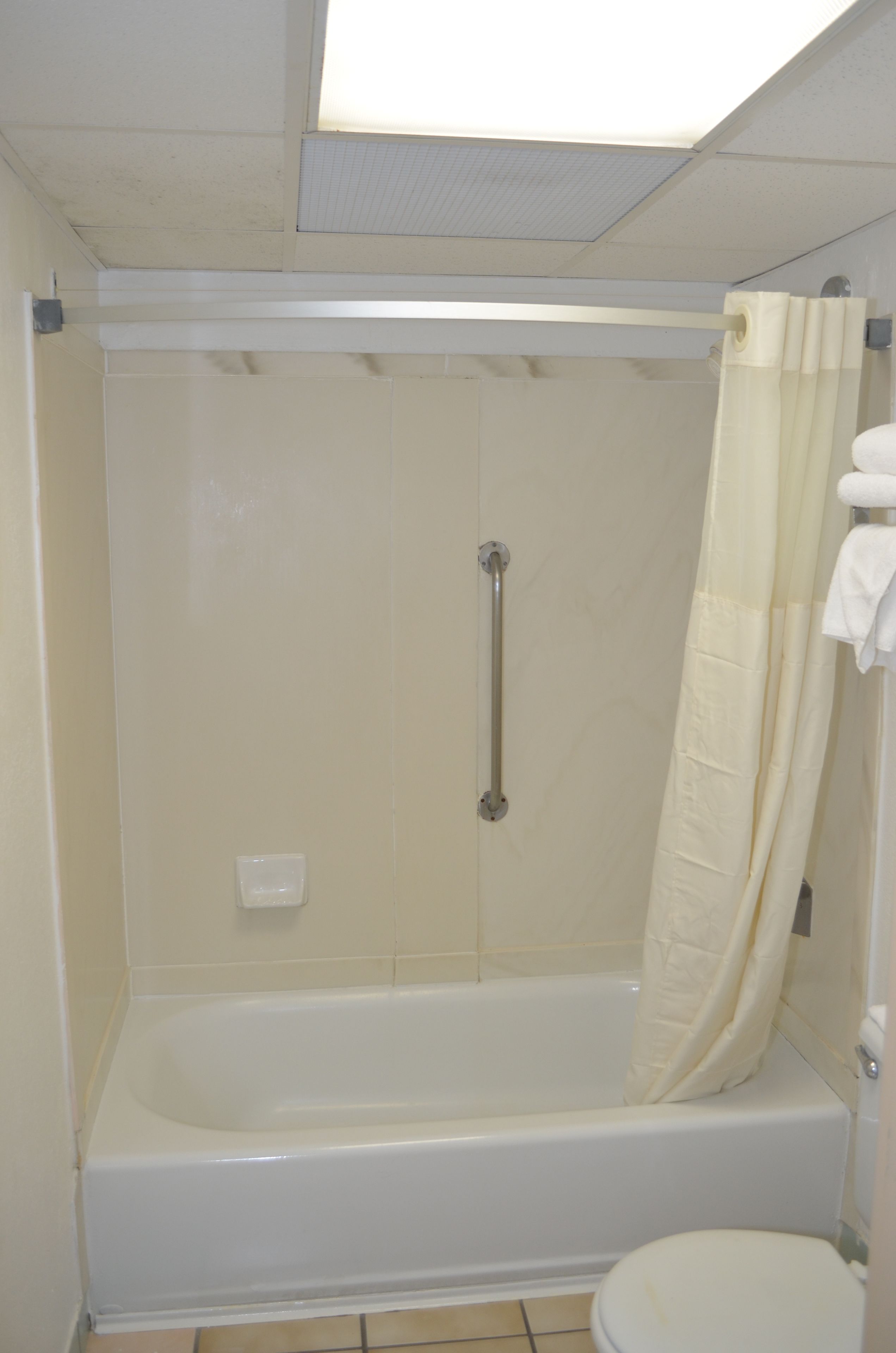 A standard bathroom with a bathtub, toilet, and shower curtain.