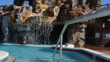 Una piscina cristalina con una cascada y un telón de fondo rocoso.