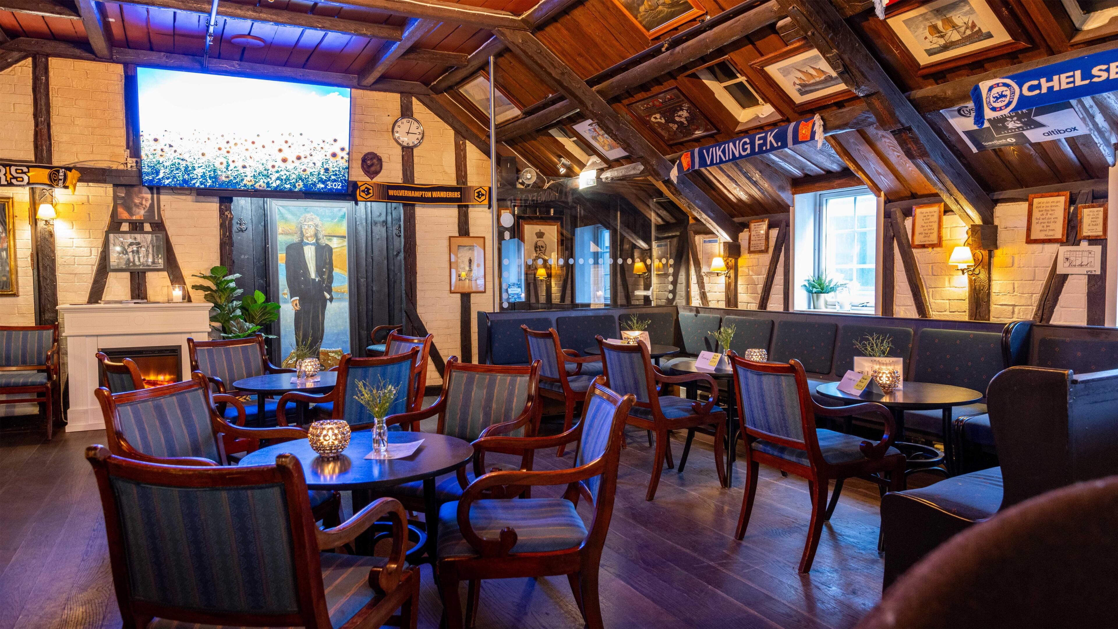 Un restaurante acogedor con mobiliario de madera, una chimenea y un letrero que indica temática vikinga.