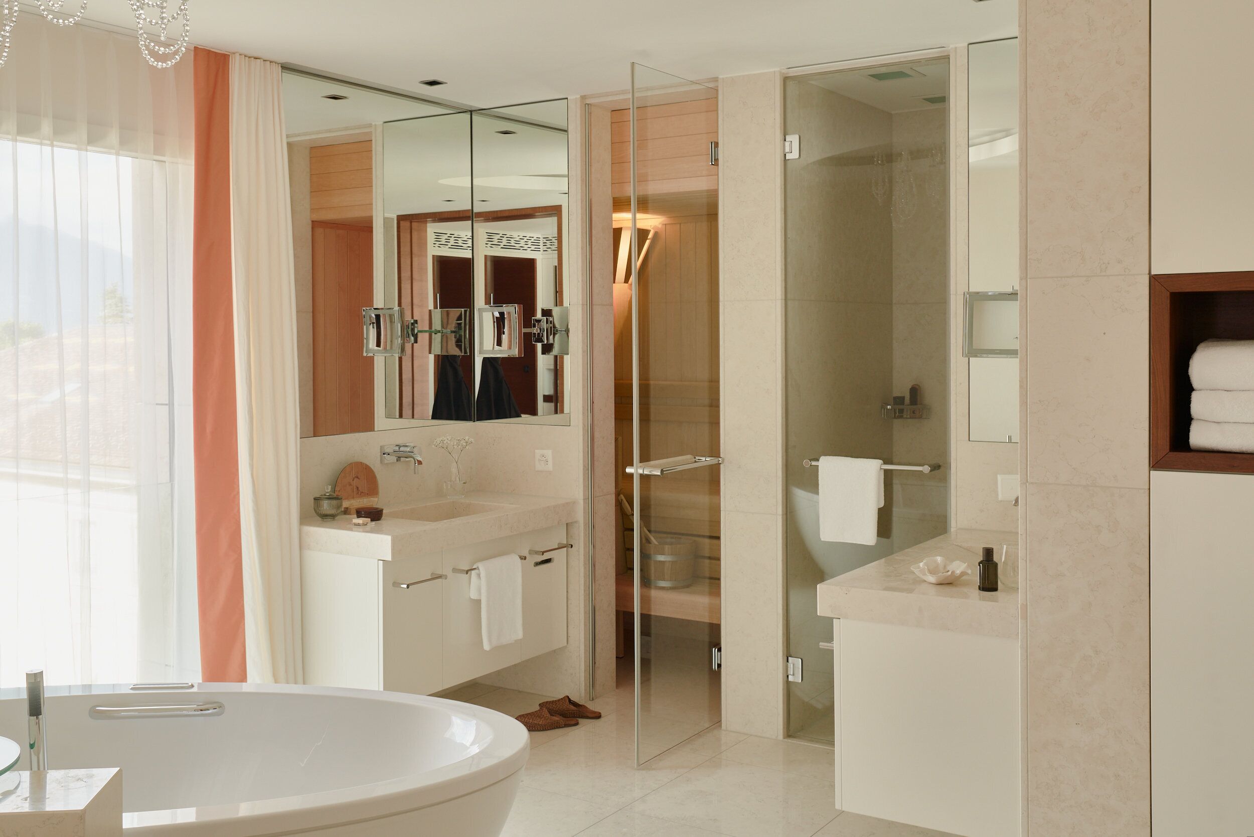 A modern bathroom with a large bathtub, a glass shower enclosure, and a vanity with a mirror.