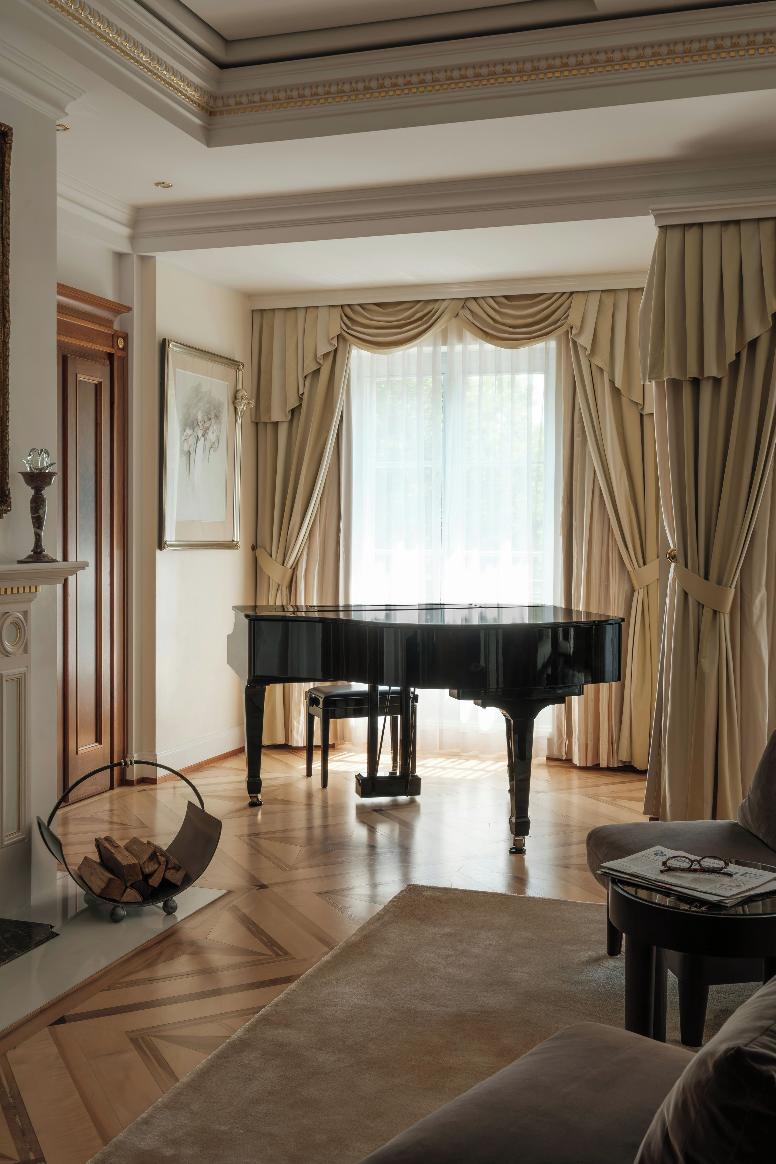 Um piano de cauda imponente numa sala ampla, com uma grande janela, lareira e área de estar aconchegante.