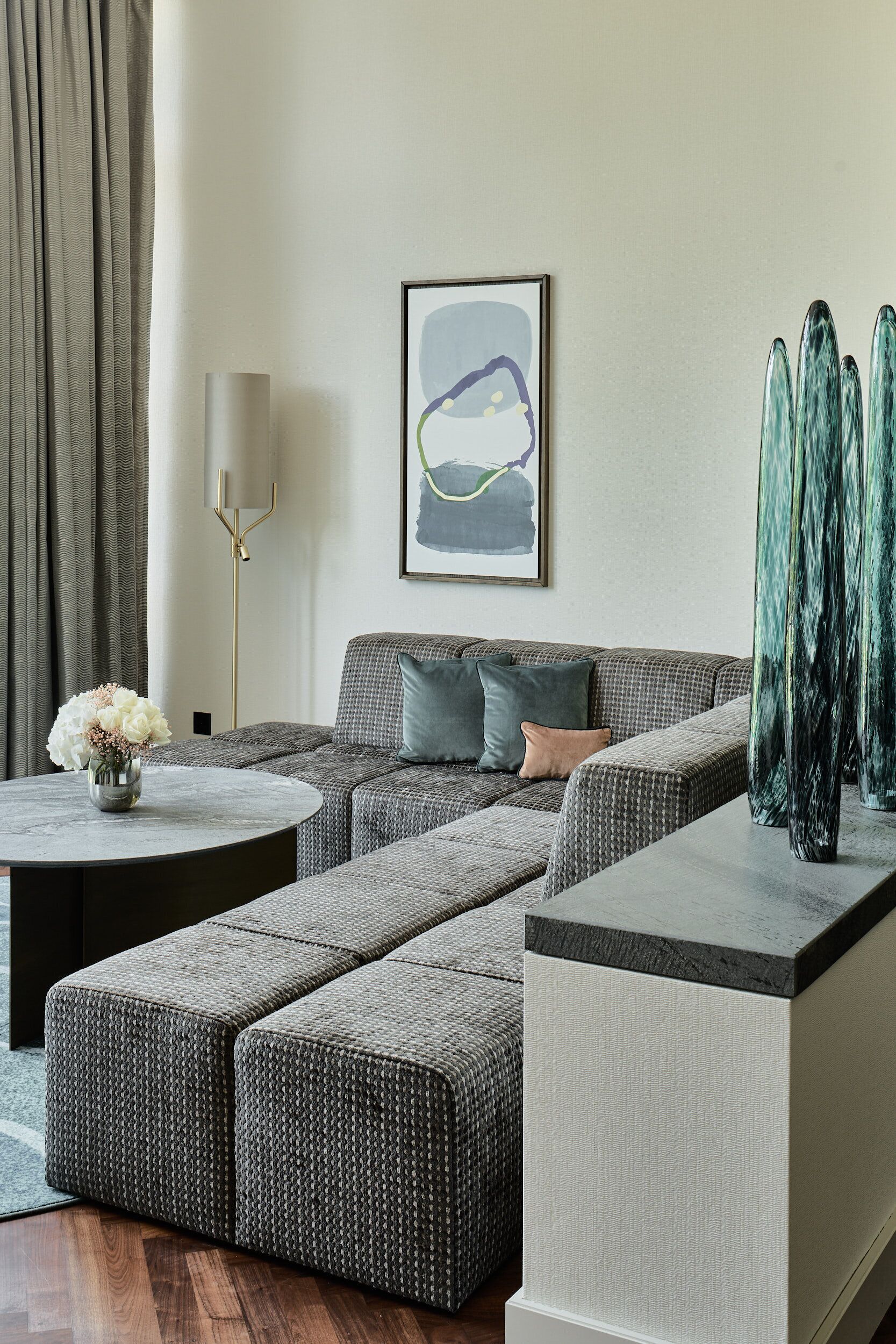 A modern living room with a sectional sofa, a round coffee table, and a tall floor lamp.