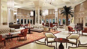 A spacious lobby with a large seating area, a palm tree, and a chandelier. - Taj Samudra (Colombo)