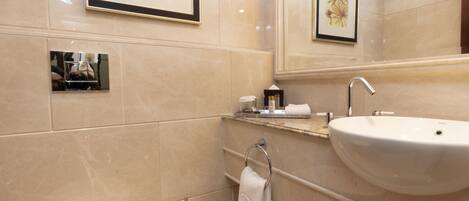 A modern bathroom with a toilet, sink, and framed artwork on the wall.