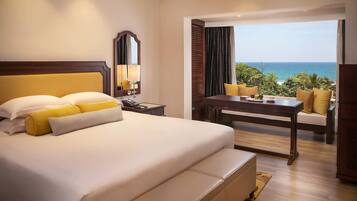 Relax in comfort with a large bed, wooden desk, and ocean views.