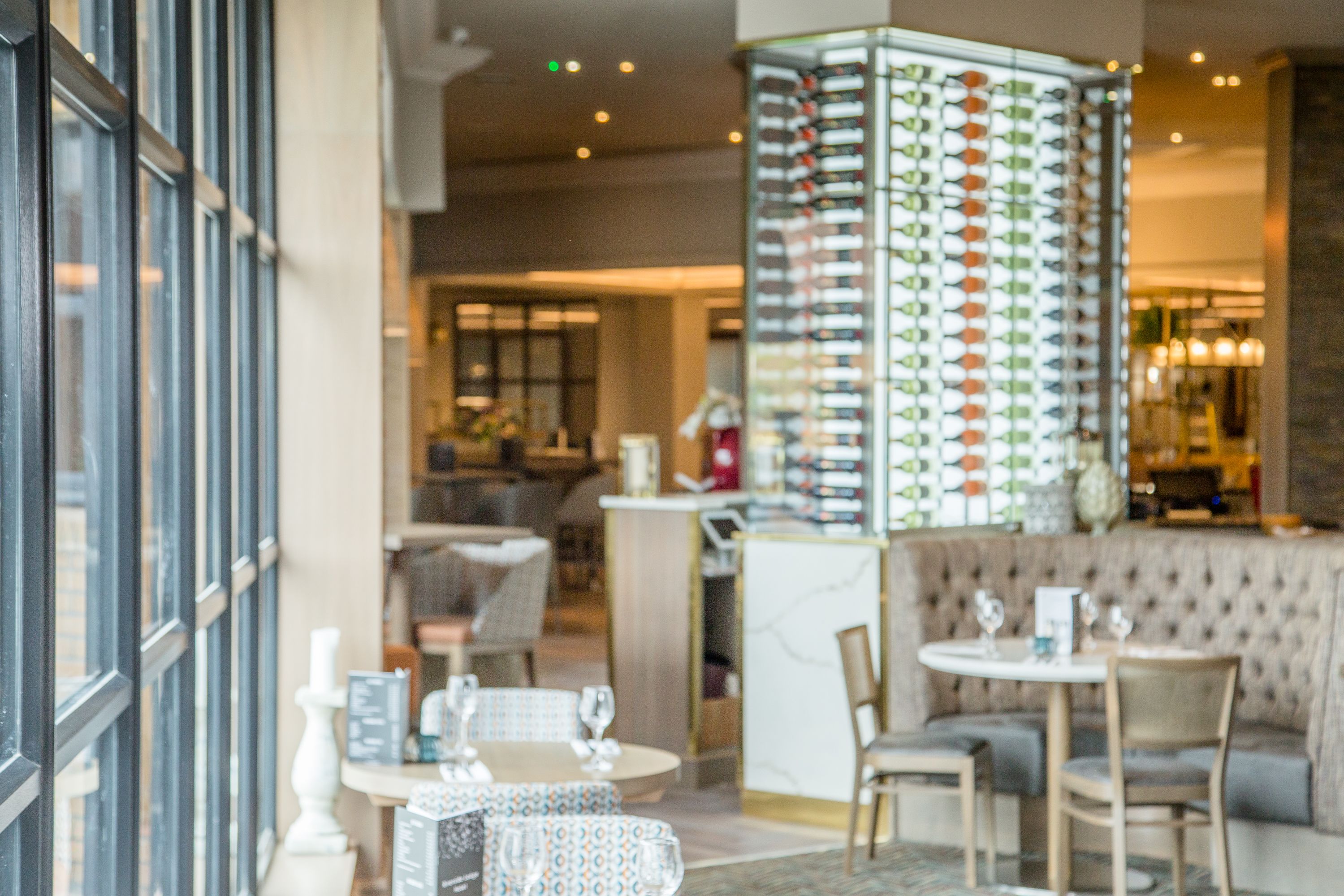 A restaurant interior with a bar area, seating arrangements, and a patterned column.