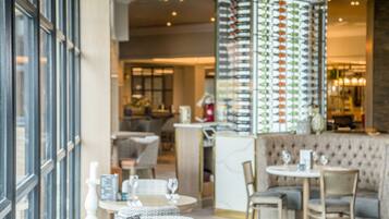 A restaurant interior with a bar area, seating arrangements, and a patterned column.