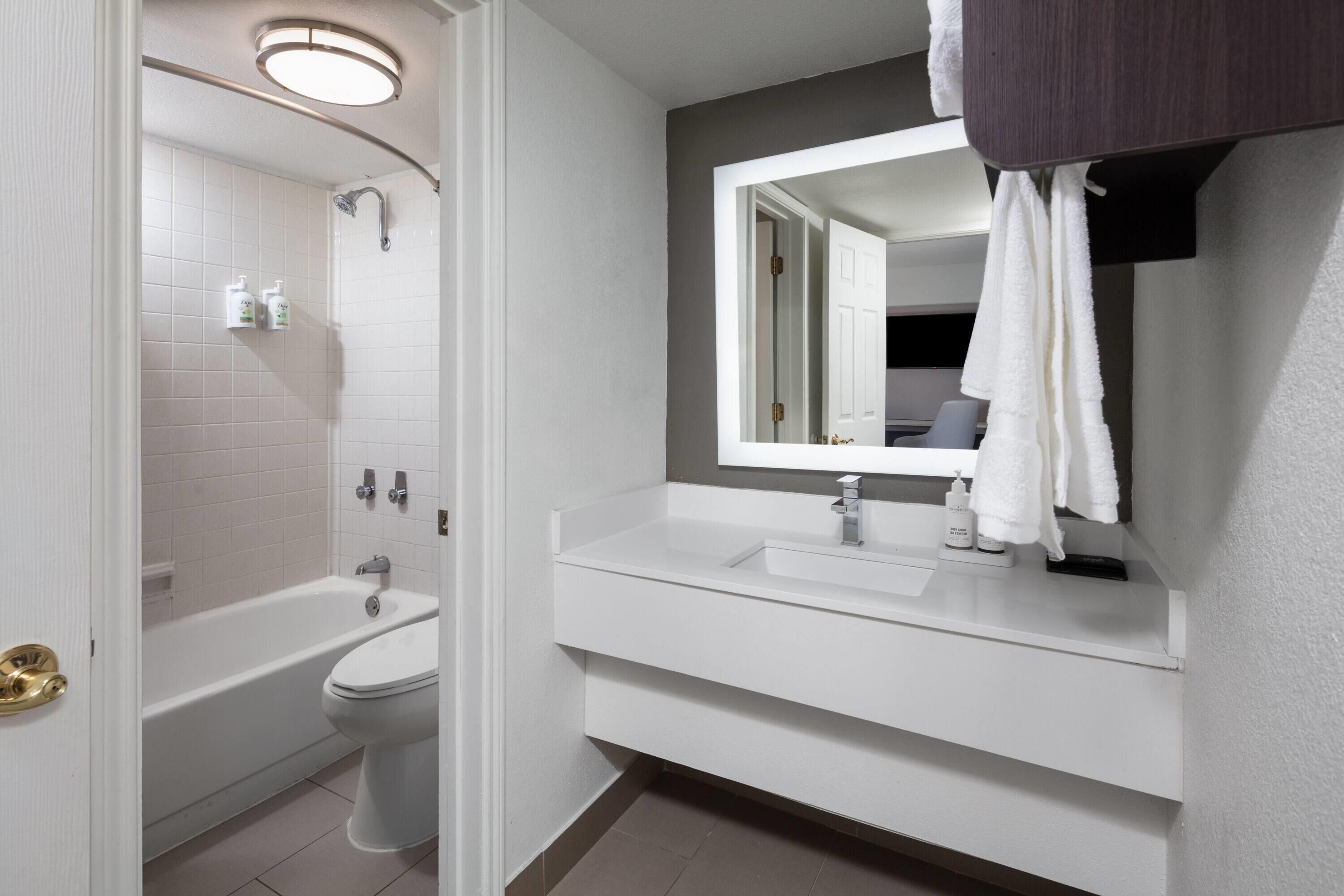 Une salle de bain moderne équipée d’une baignoire, de toilettes et d’un lavabo.