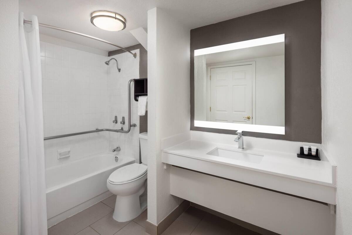 A modern bathroom with a shower, toilet, and sink.